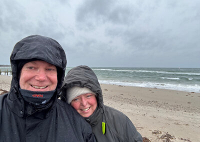 in dicke Wintersachen eingemummelt vor stürmischer See beim Spazieren